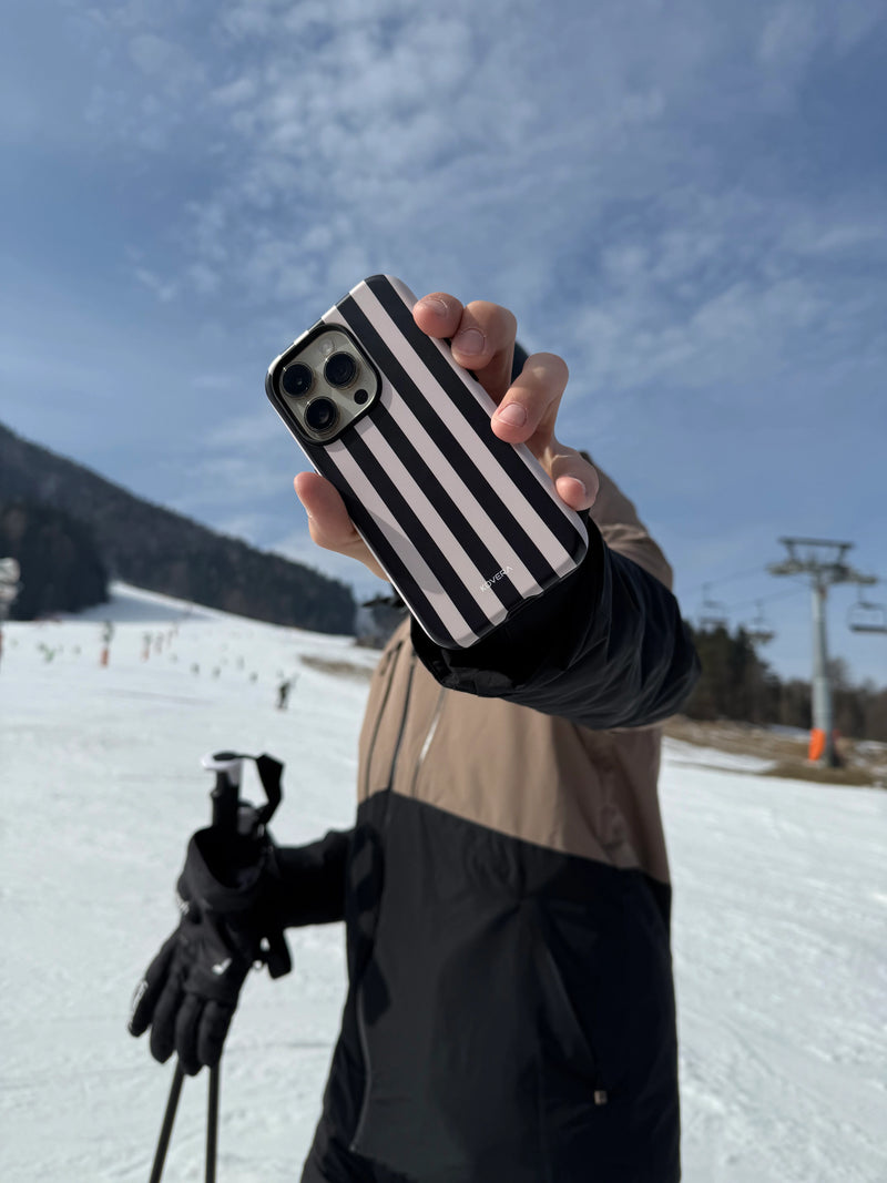 Ochranný kryt na iPhone Kovera v horskom prostredí, zákazník drží mobil na svahu, reálne používanie obalu v zime