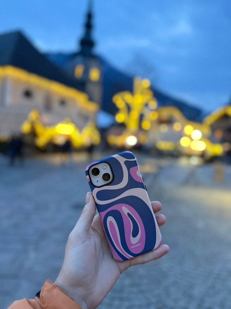 Ochranný kryt na iPhone Kovera s farebným vzorom, reálne používanie mobilu v meste počas večera, lifestyle fotografia zákazníka